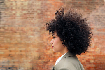 profile portrait of a young latin woman with curly hair, copy space for text