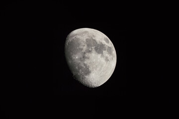 Sharp image of the moon in the waxing gibbous phase shown against a dark sky in Southern California.