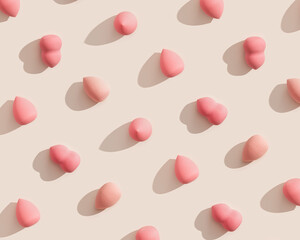 Trend pattern from makeup sponges beige and pink color for foundation cream on beige color background with dark shadows. Geometric flat lay beauty blender, cosmetic sponge, make up puff