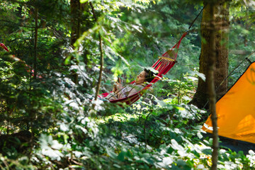 woman laying down in hammock reading book