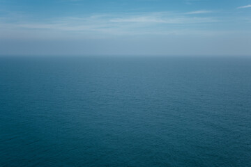 The front view of the sea with morning sky and fuzzy horizon. The ocean deep indigo color in...