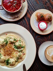 Dishes of Ukrainian cuisine on plates: borscht, donuts and dumplings