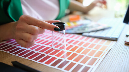 Graphic designer choosing colors samples and looking through magnifying glass