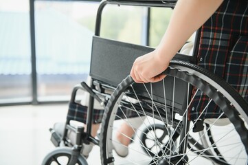 Woman in wheelchair's hand on wheel close up