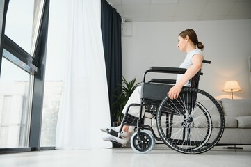 Obraz na płótnie Canvas Young woman in wheelchair at home