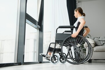 Fototapeta na wymiar Young woman in wheelchair at home