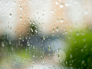 Window with a blurred summer landscape.Window with raindrops. Misted glass.