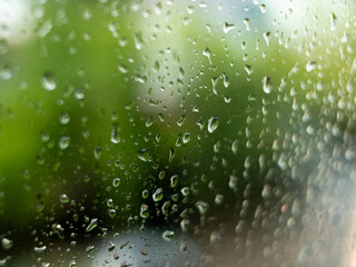 Drops of water on glass. Raindrops on the window on a blurred background. Misted glass.