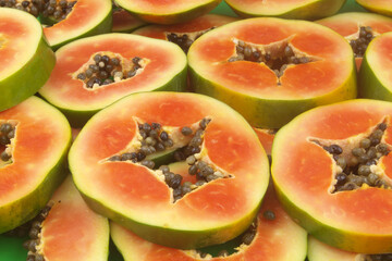 Many round red papaya fruit slices as background	