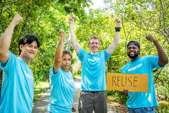 volunteering, charity, people, gesture and ecology concept - group of happy volunteers showing thumbs up and greeting you in park