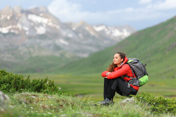 Naklejka na ściany i meble Hiker sitting contemplating views in the mountain