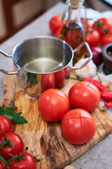 blanched tomatoes on wooden cutting board ready for peeling at domestic kitchen