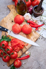 blanched peeled tomatoes on wooden cutting board at domestic kitchen