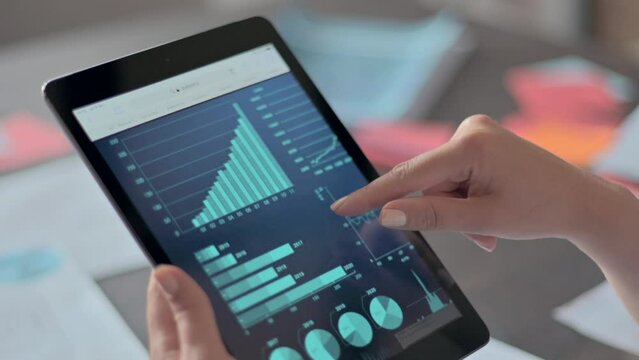 Woman wearing blue business suite working at the office using tablet and notebook