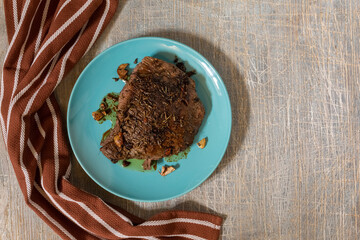 juicy steak with blood fried in a pan, top view, traditional food