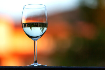 One white wine glass on the sunset blur background
