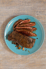 juicy steak with blood fried in a pan, top view, traditional food
