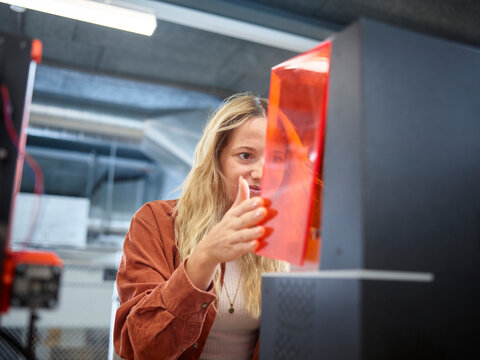 Technician opening SLA printer at workshop