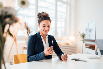 Happy businesswoman with self testing kit sitting at desk