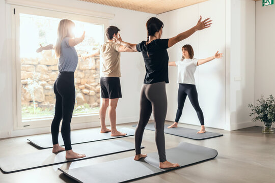 Instructor teaching yoga class in health club