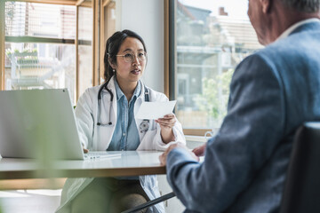 Doctor discussing with patient over prescription in medical clinic