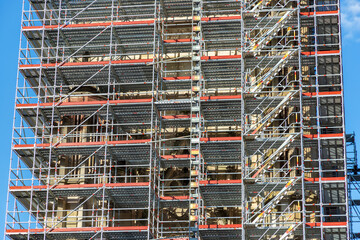Giant scaffolding, mobile metal scaffold. The building is under construction, with metal scaffolding.