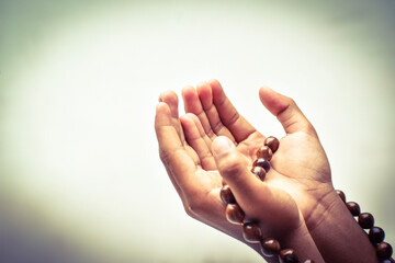 Muslim child man lift two hand for praying and wearing bead on hand to determine the number of prayer services,isolated on white background.concept for Ramadan, Eid al Fitr, eid ad-ha, meditation