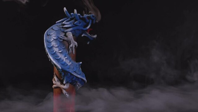 Chinese long dragon in a smoky room exhaling fumes on a pole while rotating slowly
