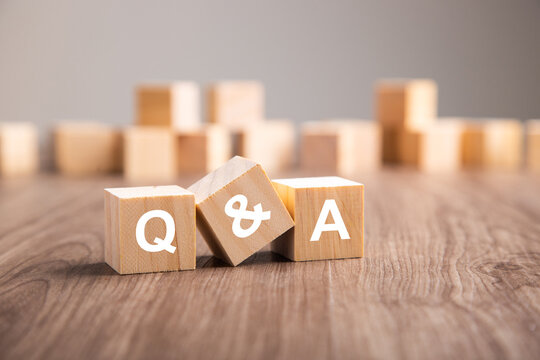 Three wooden cubes with the letters Q and A.