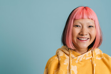Asian girl with pink hair and piercing laughing while looking at camera