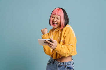 Asian girl gesturing while playing online game on mobile phone