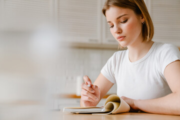 Smiling young woman writing in her diary