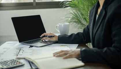The businesswoman hand sits at their desks and calculates financial graphs showing the results of their investments planning the process of successful business growth