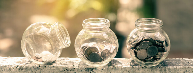 Retirement savings concept. bottle glass and coins with green nature background and copy space