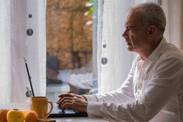 adult man using pc while having breakfast at home