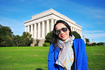 an Asian woman in front of the Lincoln Memorial in Washington DC, USA
