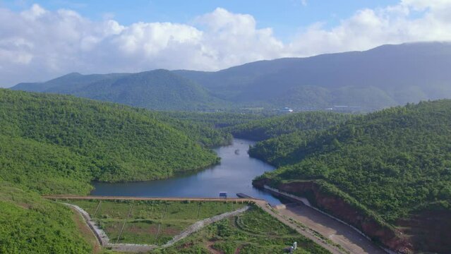 Aerial landscape with green hills, river dam and forest