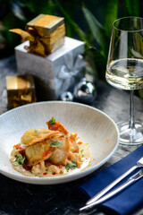 fried ravioli with meat in sauce and herbs in a plate on the table with a glass of wine
