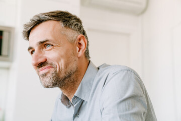 Adult handsome smiling man looking aside over white background