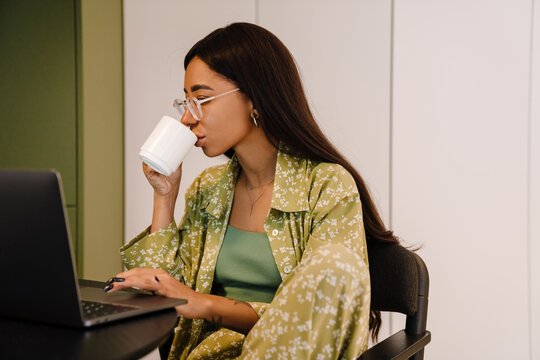 Young Beautiful Long-haired Woman In Glasses Working On Laptop