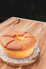Golden Brown Chiffon Cake on white doiley paper on top of wood table