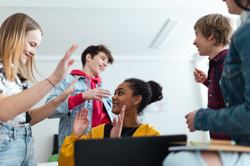 High school students meeting and greeting in classroom after school holidays, back to school concept.