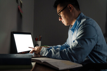 Adult focused man in glasses working / studying with laptop