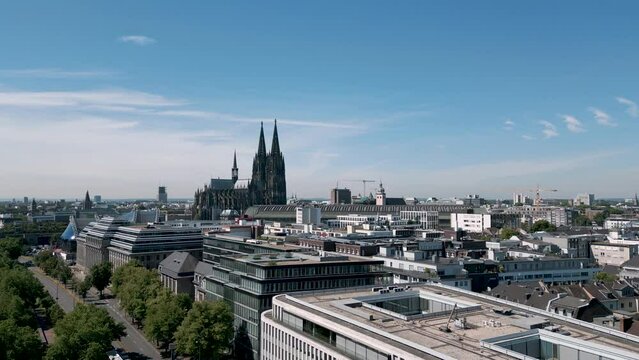 Cologne, Germany - Rising drone flight bird view shows the panorama of Cologne with the famous and popular with tourists Cologne Cathedral. An Establisher shot with amazing blue summer sky. Luftbild