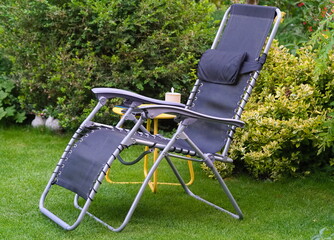A deckchair on the lawn in the home garden - 516293407