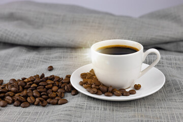 A cup of coffee and coffee beans on burlap