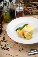 mashed potatoes with cutlets decorated with basil leaves in a white plate, vertical photo
