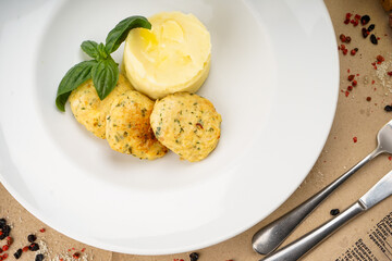mashed potatoes with cutlets decorated with basil leaves in a white plate macro photo
