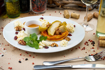 breakfast baked fruits with cottage cheese, nuts and honey in a plate
