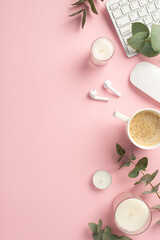 Business concept. Top view vertical photo of workspace keyboard candles computer mouse cup of coffee wireless earbuds and eucalyptus on isolated pink background with copyspace
